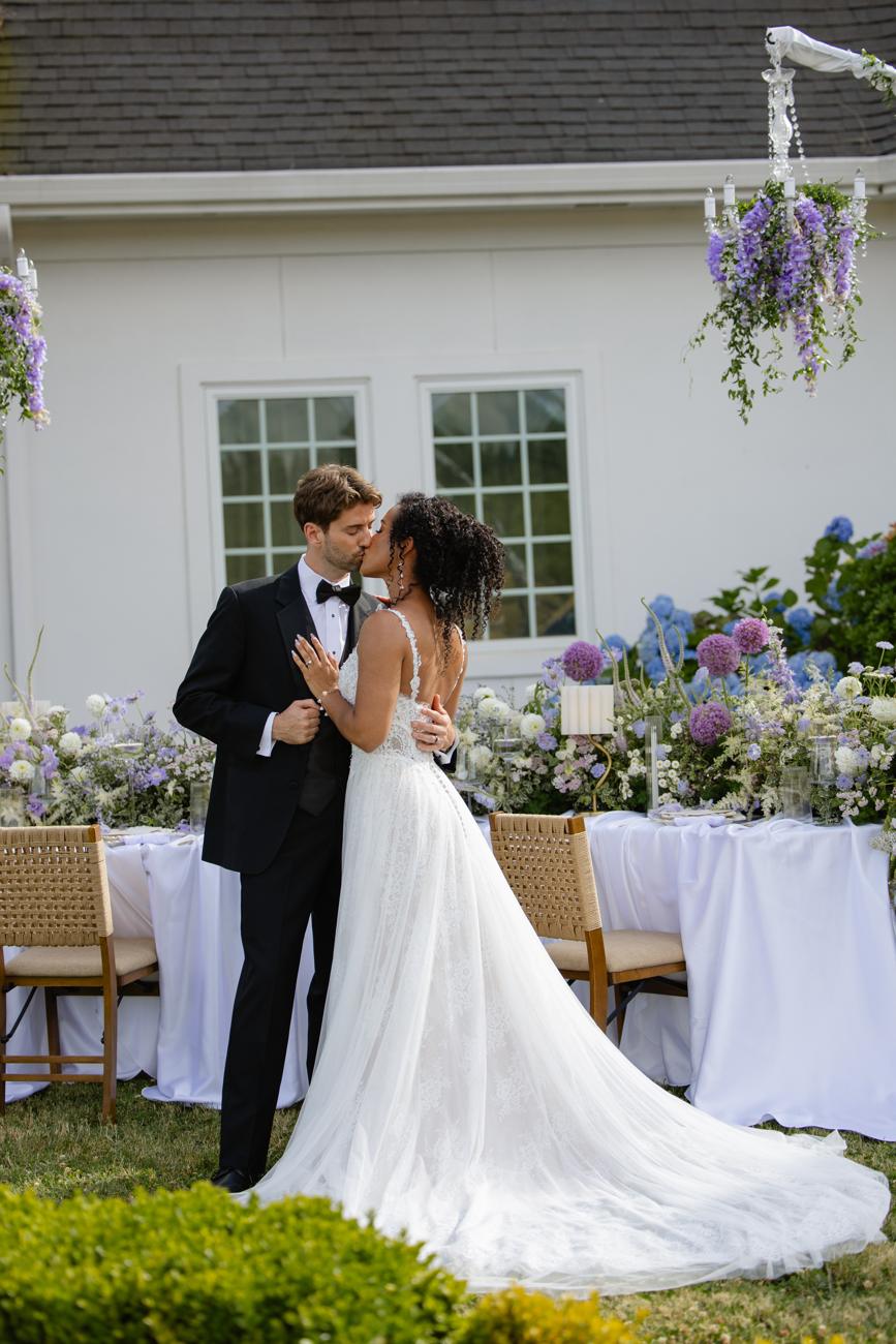 A kiss beside the flower-covered table